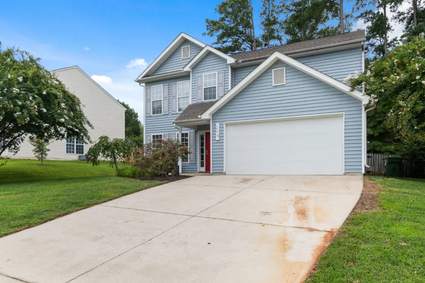 Two-story suburban home with driveway and mature landscaping