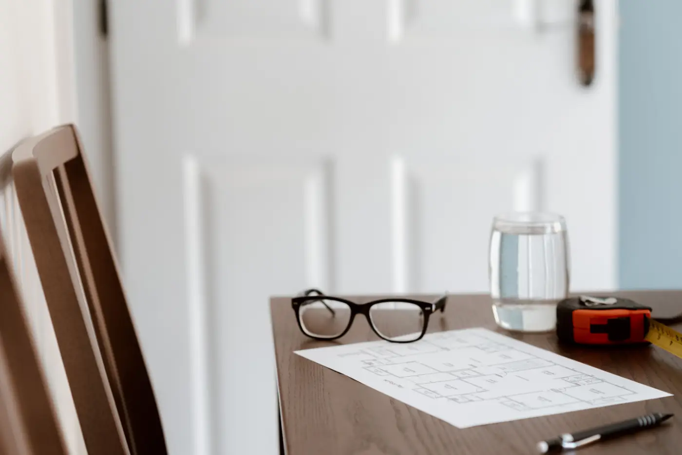 Residential plans, glasses, and a measuring tape on a professional workspace
